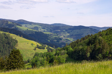 Fototapeta na wymiar Summer mountains landscape, view on Black Forest mountains and valley. Springtime hills, fields, meadows and forest. Schwarzwald panorama, rolling landscape. Germany