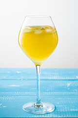 Cold summer delicious coctail with lime and ice in a glass with drops on the white and blue background.