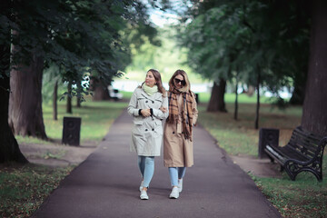 Fototapeta premium autumn fashion park girls two look / walk in a city park two glamorous fashionable girlfriends in a coat