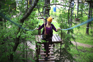 extreme vacation, girl in a yellow helmet rope park active holidays in the forest