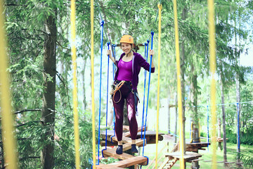 extreme vacation, girl in a yellow helmet rope park active holidays in the forest