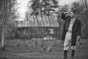 vintage man young village black and white, eastern europe style, retro coat and boots