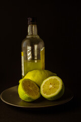 limoncello licor de limón tradicional italiano con botella, copa y mitades de limón fresco