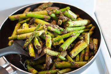 Stir the asparagus while frying in a pan in sunflower oil