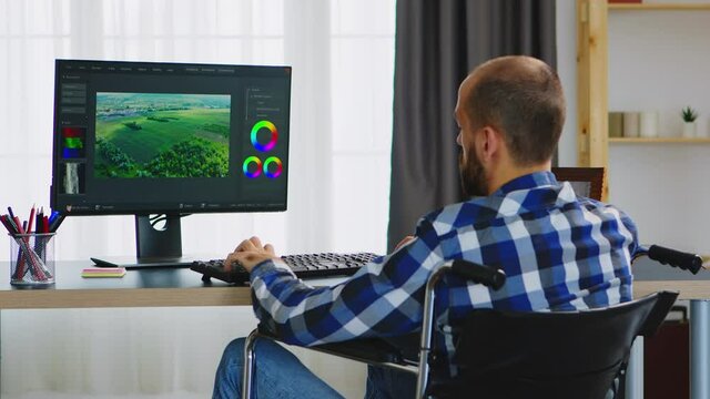 Disabled videographer in wheelchair working from home office. Handicapped invalid paralysed freelancer, immobilized entrepreneur working from home, ilness and disability