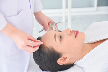 Obraz na płótnie Canvas Beautiful asian woman receiving facial acupuncture treatment at clinic ,Alternative medicine concept.