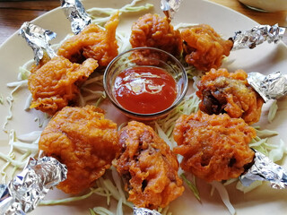 chicken lolipop, chicken winglet, tandoori chicken. Famous indian non veg dish, roasted chicken covered with silver foil