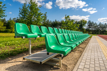 Two rows of green plastic seats on the stadium