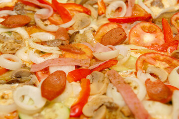 Pepperoni with meat, sausage, and vegetable toppings Italian pizza pie