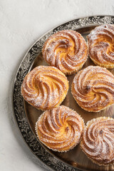 Muffins in powdered sugar served in metal tray. View from above