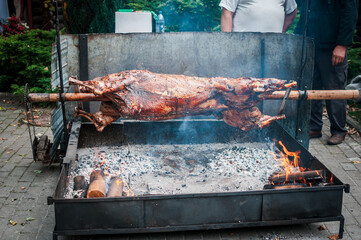 The carcass of the calf is baked on the grill, rotates on a spit