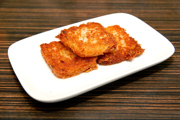 Fried radish cake served on white plate