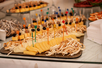Wedding buffet. Slicing different varieties of cheese