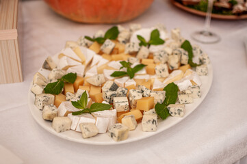 Wedding buffet. Slicing different varieties of cheese