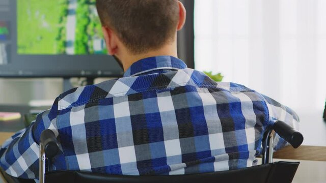 Disabled professional film maker in wheelchair working from home office. Handicapped invalid paralysed freelancer, immobilized entrepreneur working from home, ilness and disability