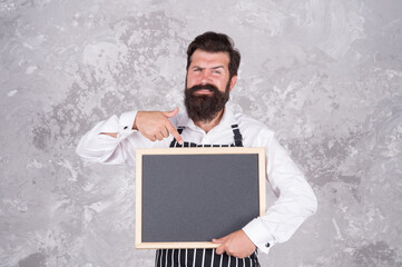 should try this. restaurant chef cuisine. brutal bearded man with blackboard. hipster barista pointing finger. feel the success. cafe chalkboard menu. unhappy cooking in kitchen. presenting product