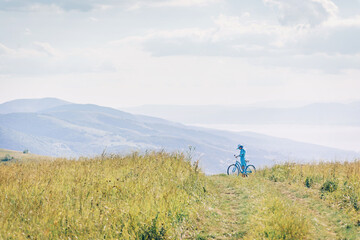 Woman walking on path among green grass meadow.