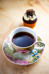 Chocolate cupcake with pieces of chocolate bar and coffee