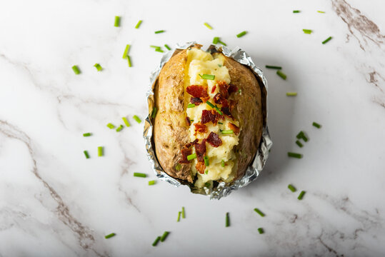 Home cooking jacket potato, filled with sour cream, bacons and chives