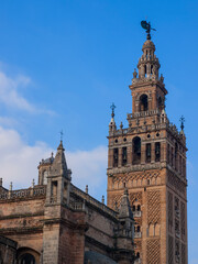 Fototapeta na wymiar Giralda de Sevilla, has the structure of the Almohad minarets, is topped with a female sculpture called 