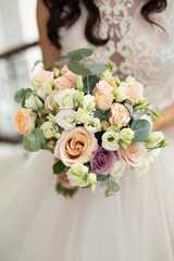 Wedding bouquet of colorful roses in the hands of the bride.