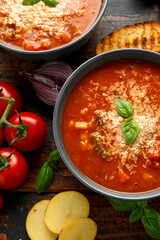 Seasonal vegetables classic minestrone soup with pasta served with cheese, grilled sour dough bread and basil leaves