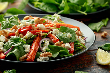 Roasted carrot salad with feta cheese, walnut and spinach. healthy food