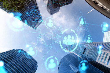Obraz premium Social media icons hologram on low, wide angle view of glass and steel contemporary skyscrapers in financial downtown. The concept of people networking and success. Double exposure.
