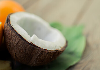 Tropical fruit on the wooden background. Fruits background. Coconut and oranges on a wooden table.