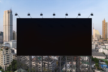 Obraz premium Blank black road billboard with Bangkok cityscape background at day time. Street advertising poster, mock up, 3D rendering. Front view. The concept of marketing communication to promote or sell idea.