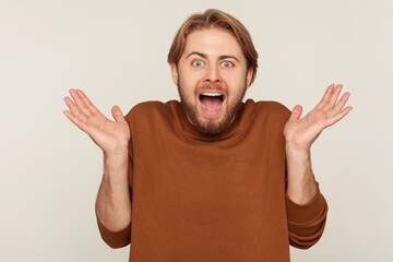 Oh my god, wow! Portrait of happy astonished excited bearded man standing with open mouth and...