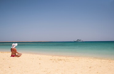 young woman in bikini on the beach meditation