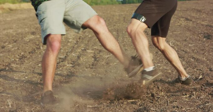 Two brisk fighters training arm and legs' hits among field