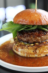 Hamburger close-up on black background. Fresh vegetables and grilled meat.