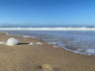Fototapeta na wymiar Beach foam. Sand and water