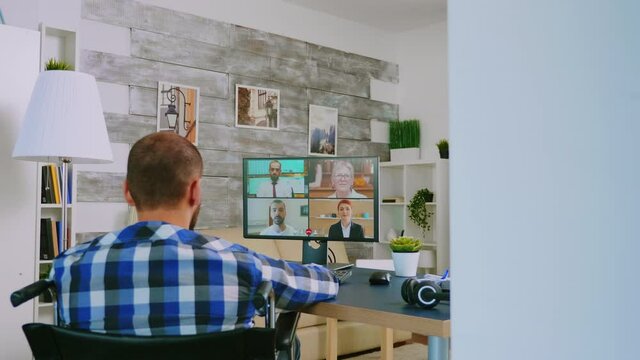 Disabled freelancer in wheelchair during a video call working from home. Handicapped invalid paralysed freelancer, immobilized entrepreneur working from home, ilness and disability