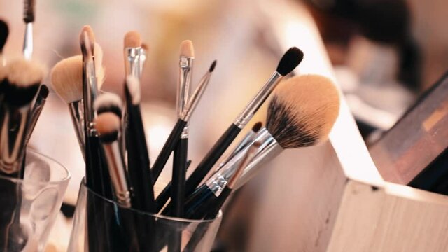 Many makeup brushes on blurred background, closeup beauty parlour equipment Various makeup brush set close-up Cosmetics and beauty concept