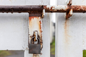 door gate closed with metal chain & rusty iron lock