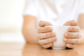 Fototapeta na wymiar Woman hands holding white coffee cup