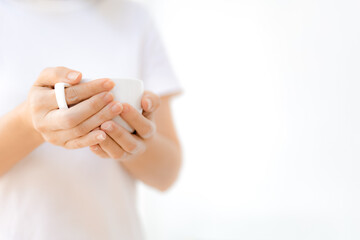 Woman hands holding white coffee cup