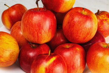 Fototapeta na wymiar Red apples lie on a light table. Close up