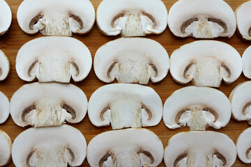 Mushroom slices pattern. Color photo of champignons on a wooden board. Vegetarian cuisine. Vegetable protein.