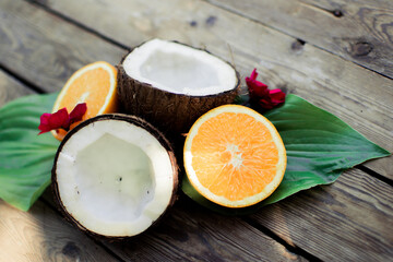 Tropical fruit on the wooden background. Fruits background. Coconut and oranges on a wooden table.