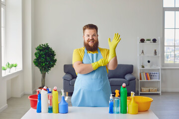 Cleaning man in room. Cheerful man in rubber gloves with cleaning products at home