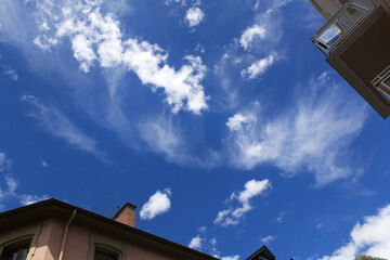 Clear blue summer sky with white clouds top view europe city building roof background