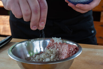 mixing minced meat with spices for cutlets. cooking burgers.