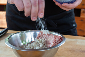 mixing minced meat with spices for cutlets. cooking burgers.