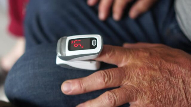 Pulse oximeter on the hand of an elderly man. Monitoring the level of oxygen in the blood of a patient in pneumonia, coronavirus covid-19