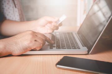 hand man put on keyboard  laptop and holding credit card,