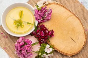 Aroma oil with flowers and wooden board